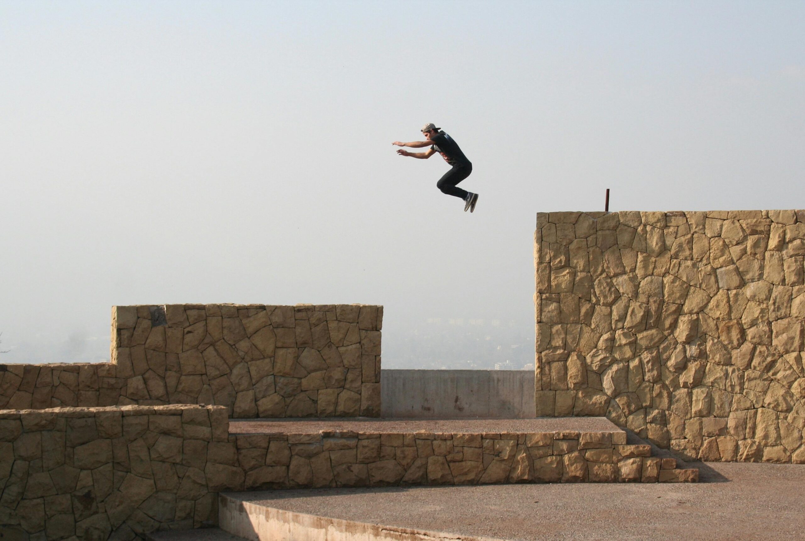 An athlete performs a thrilling parkour jump between stone walls in Recoleta, Chile.