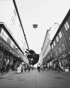 Black and white shot of a man performing parkour in Stockholm's vibrant street.